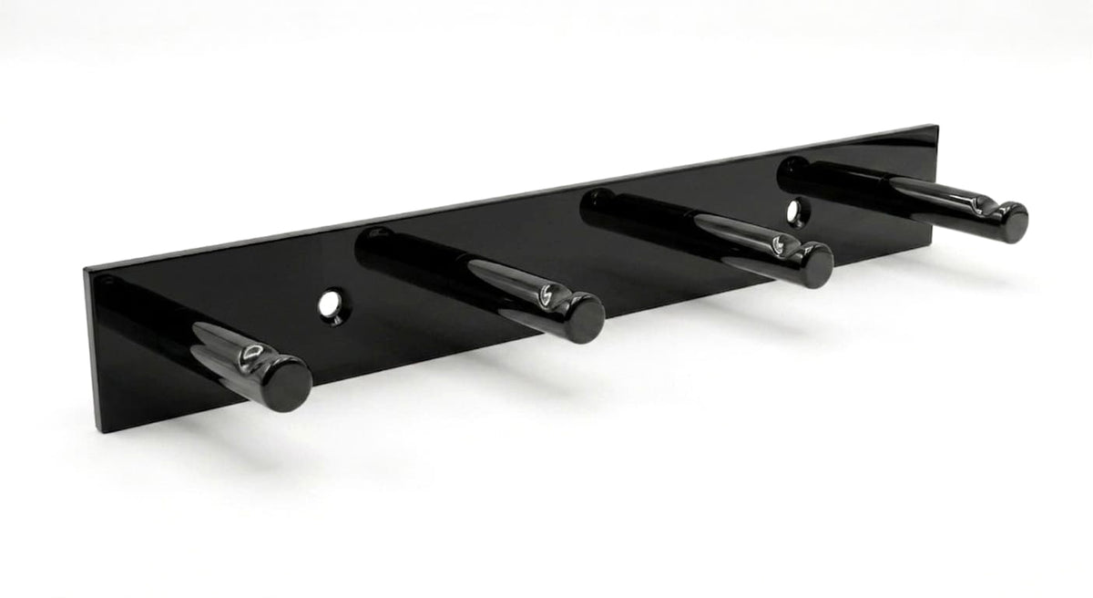Moderne Garderobenleiste aus schwarzem Metall mit vier stabilen Haken zur Wandmontage.