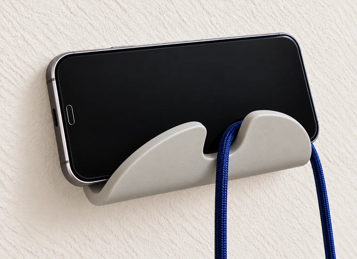 Handyhalterung an der Wand mit Smartphone und Ladekabel